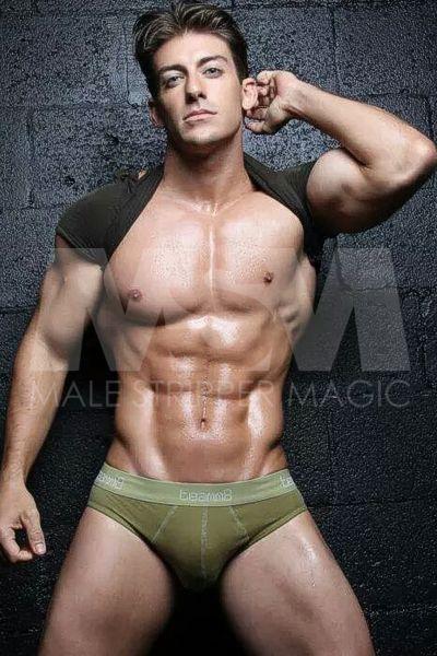 Chase, a male stripper, displaying his physique in green briefs