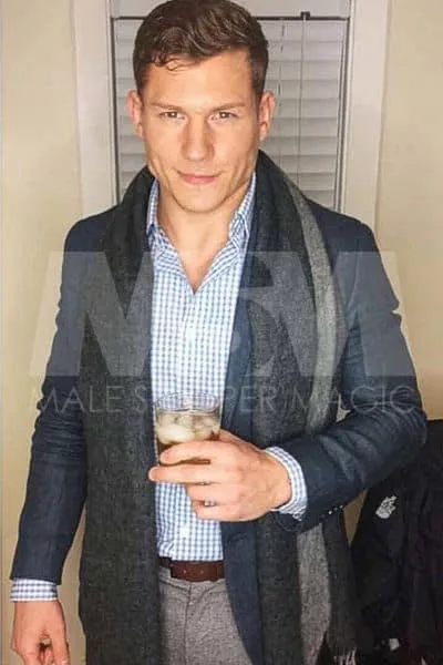  Classy Male stripper Levi in a suit jacket, enjoying a drink