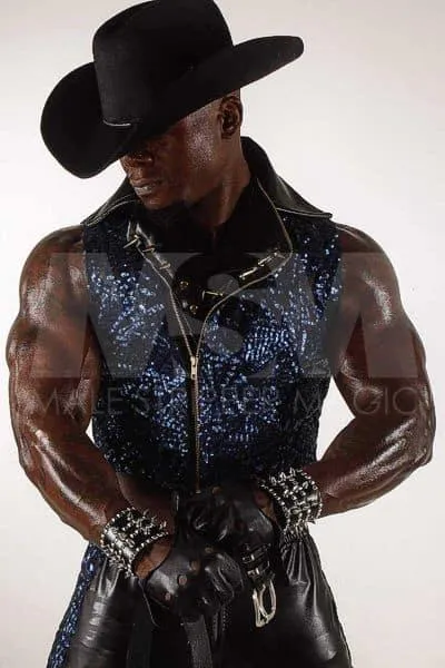 Black male stripper Incredible in cowboy attire with leather gloves and pants, showing off muscles