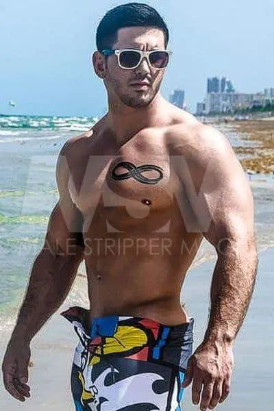 Fit Male stripper Dominic at the beach with sunglasses and trunks
