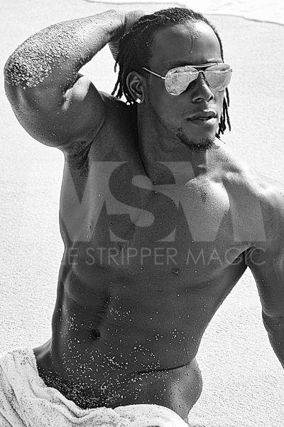 Black male stripper Kingston on the beach with sunglasses
