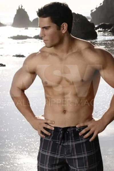 Male stripper Ethan on the beach in swim trunks