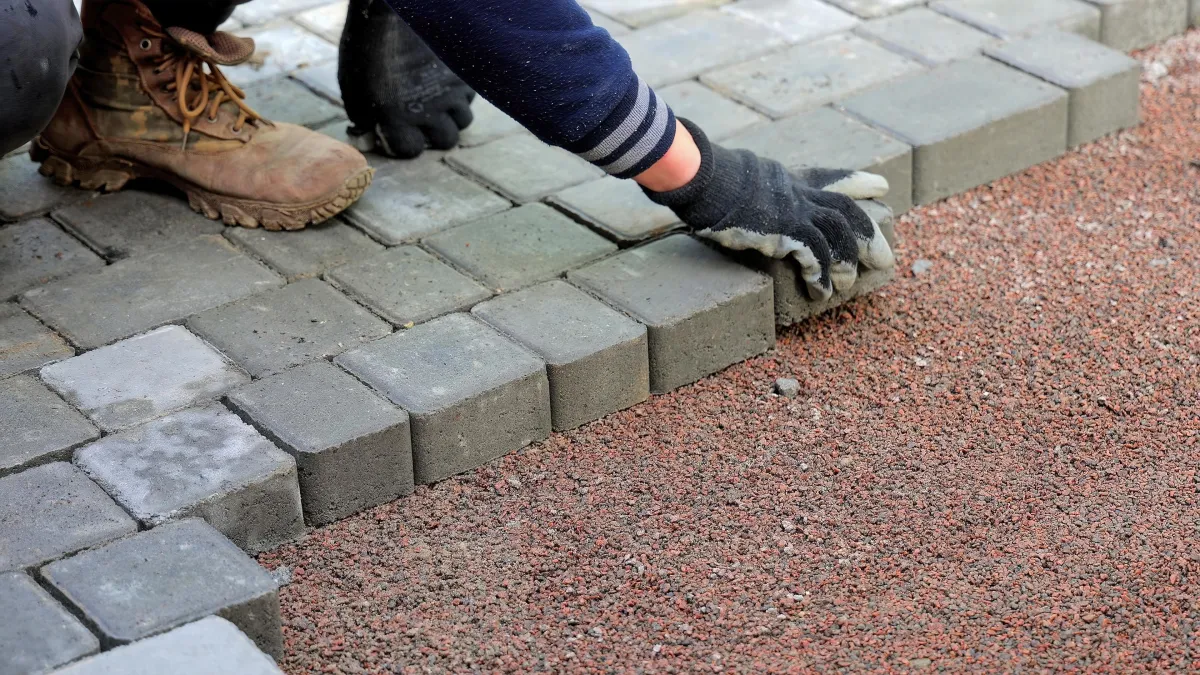 person hardscaping with grey bricks