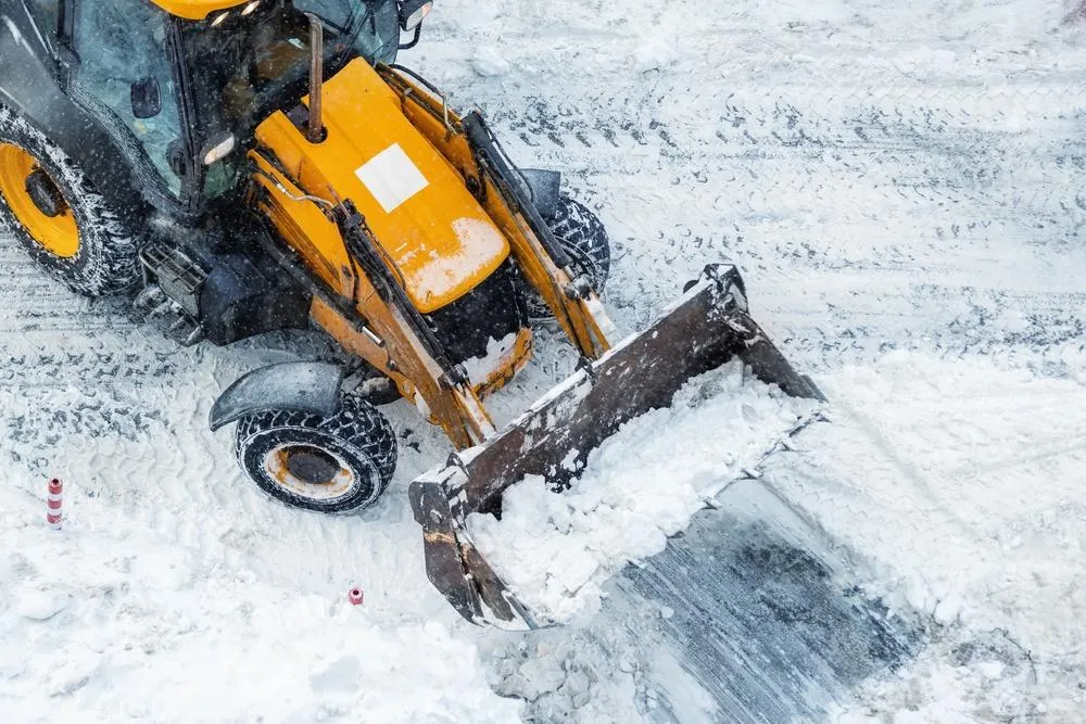 yellow skid steer removing snow
