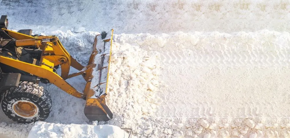 yellow skid steer removing snow