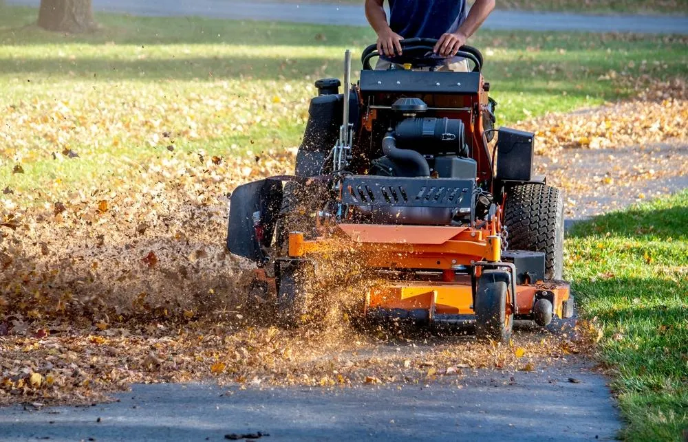 person on ride-on leaf grinder