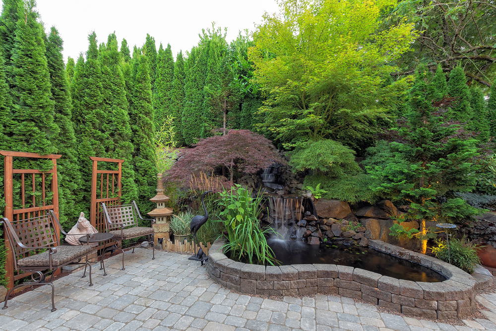 Beautiful backyard with waterfall hardscape and chairs