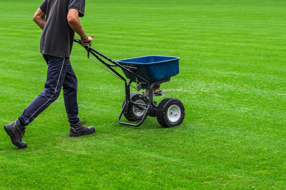landscaper pushing fertilizer