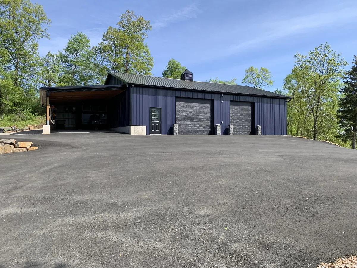 Completed dark Cimino pole building with paved vehicle access