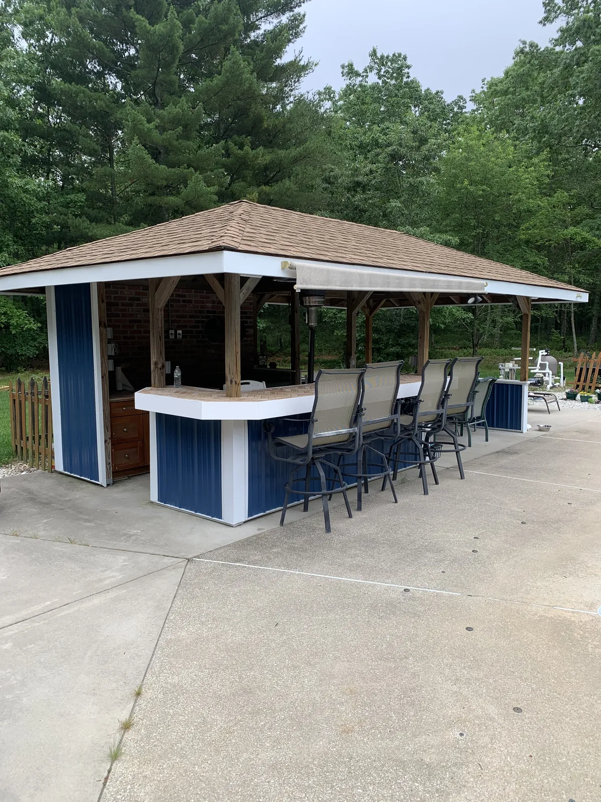 Open-sided pavilion with a bar counter and stools