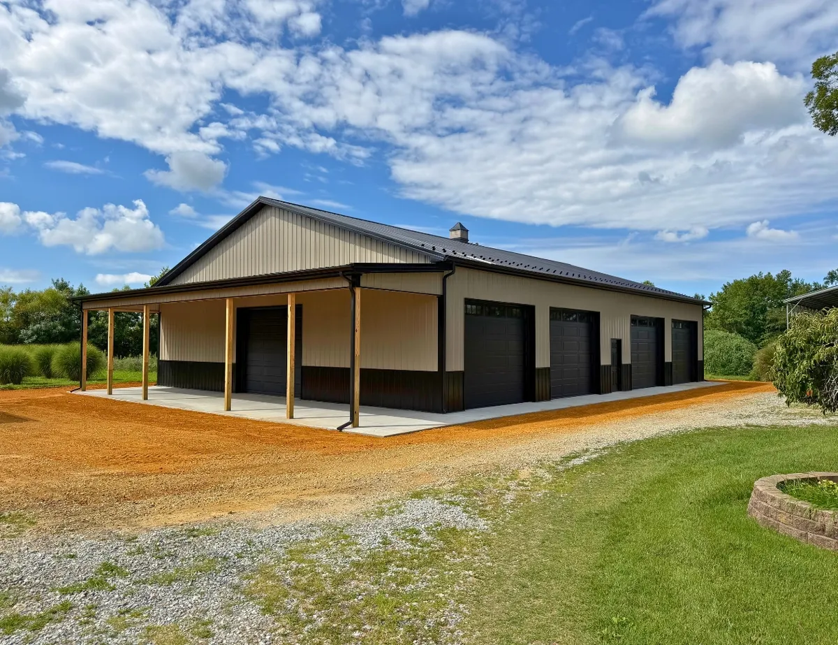 Completed multi-bay pole building with covered porch, concrete apron and lawn