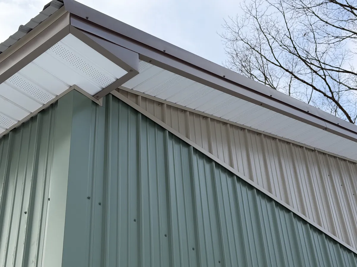 White vented soffit and contrasting trim on a green pole building