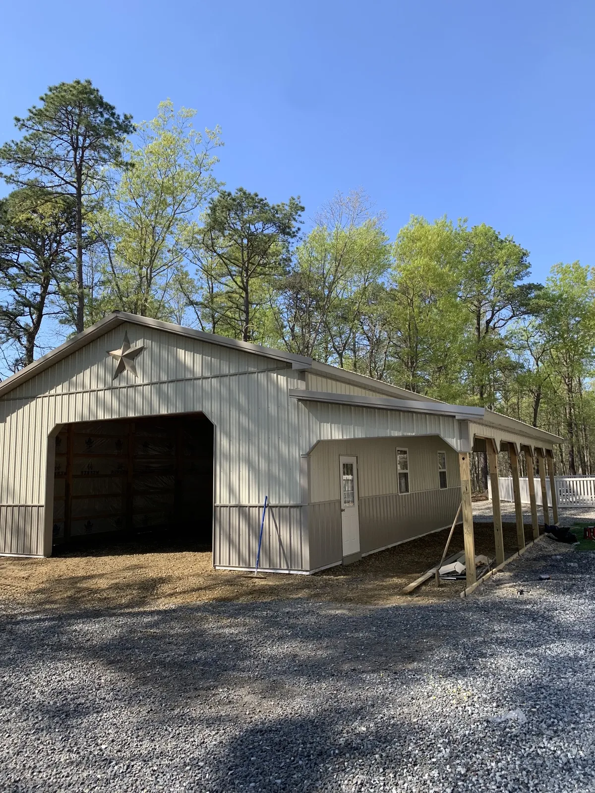 Cream barn with a tall open bay and full-length covered porch