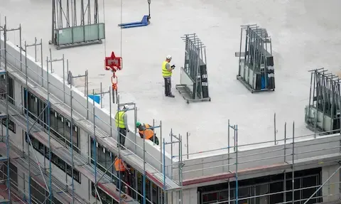 Crew installing large glass panels on a commercial building for Minneapolis Commercial Exteriors.