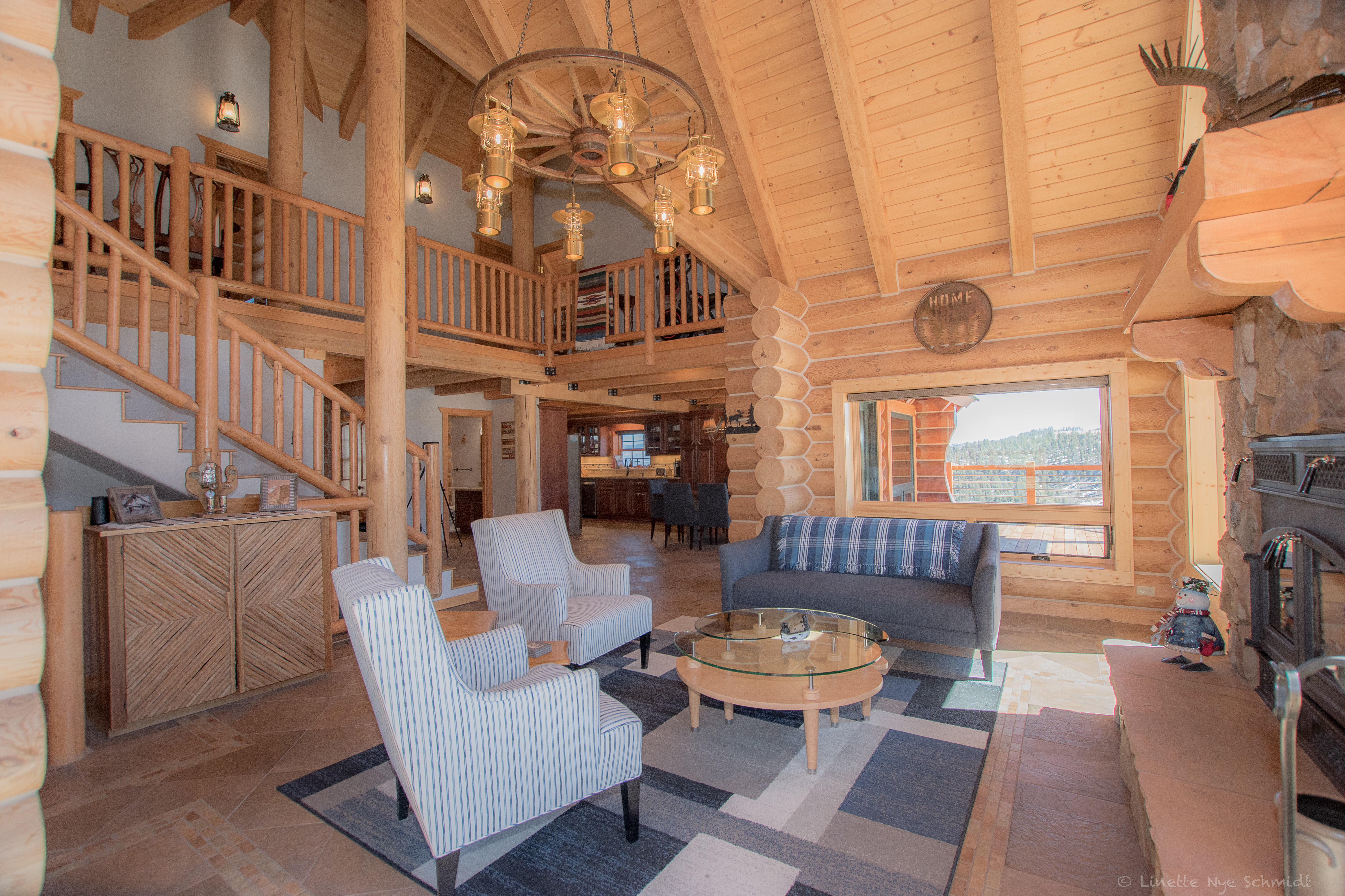 Elk Court great room with exposed timber, a stone fireplace and mountain views