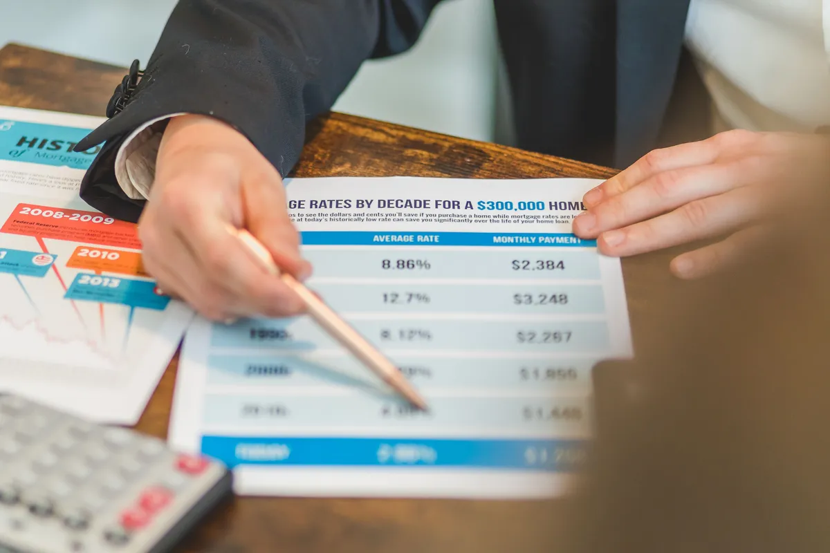Hands reviewing mortgage documents with a calculator
