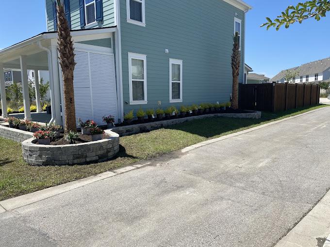 Terraced backyard with cut-stone retaining walls and herringbone paver walkways in soft mid-morning light.