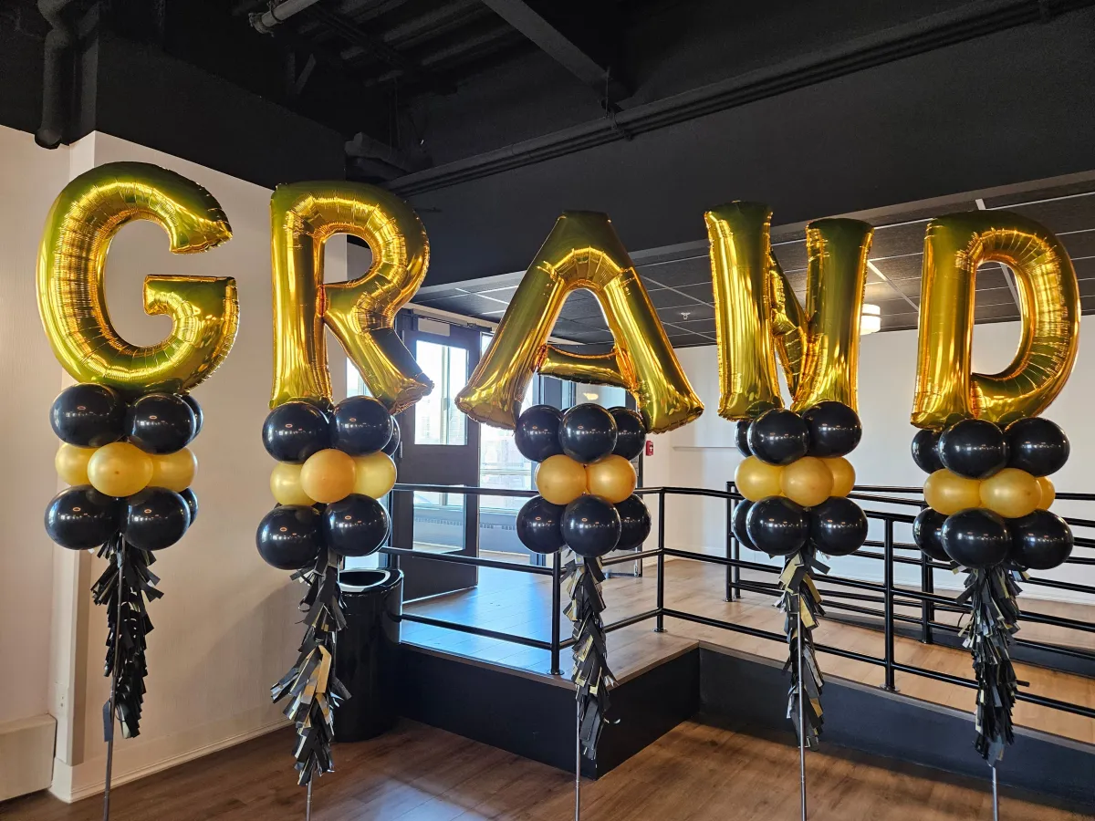Graduation balloon letters display with black and gold balloons