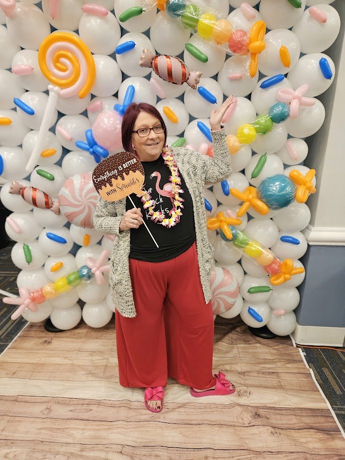 Candy-themed balloon backdrop with colorful garland and party photo setup