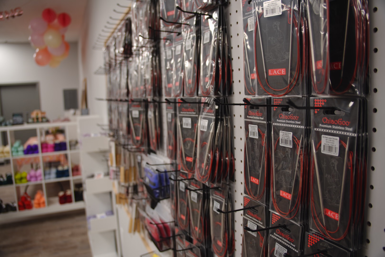 A curated selection of artisan-crafted knitting needles and crochet hooks arranged on a linen cloth, with natural wood grains and smooth finishes. The tools are elegant, functional, and designed for comfort.