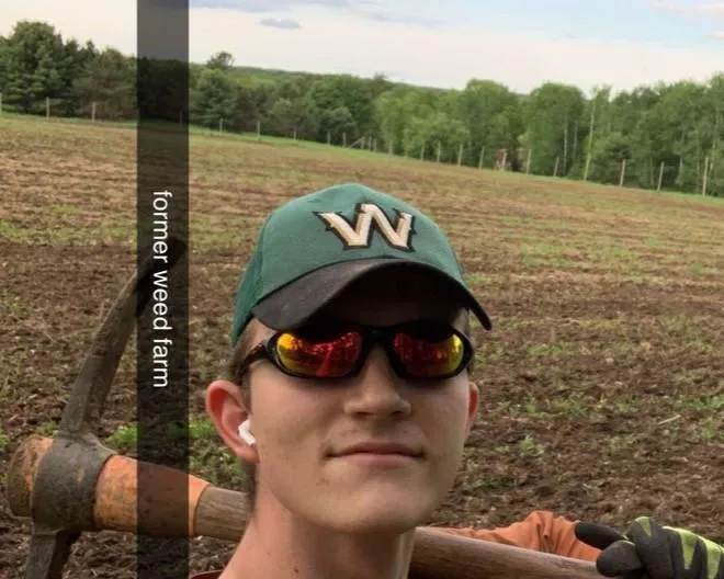 Founder of Meritez Consulting LLC in field holding pickaxe