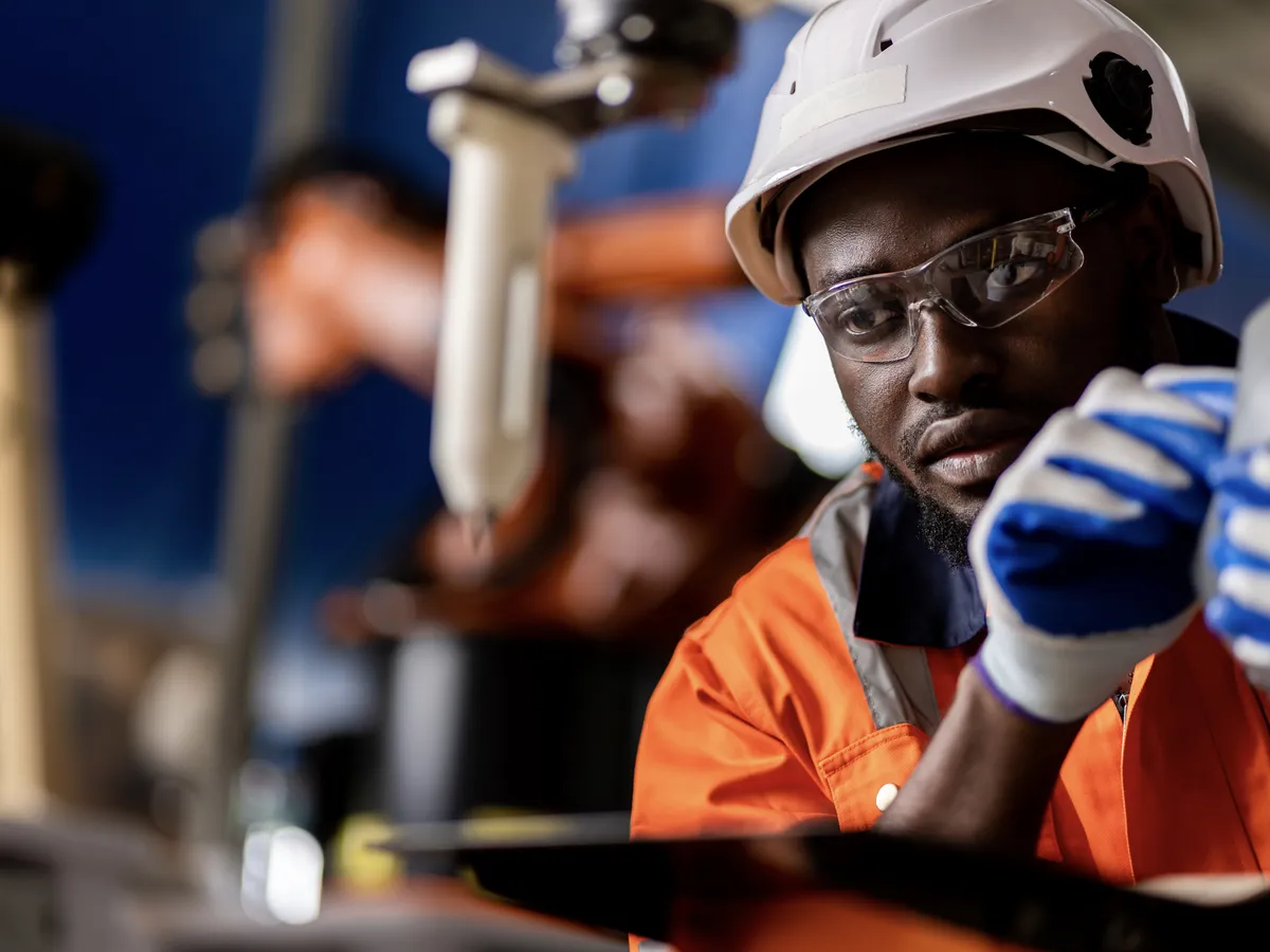 Factory worker inspecting equipment in manufacturing plant