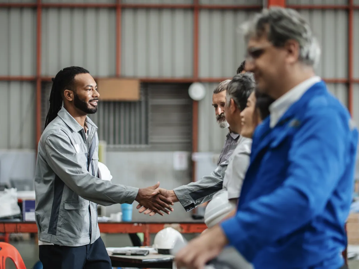 Business professionals shaking hands in an industrial setting