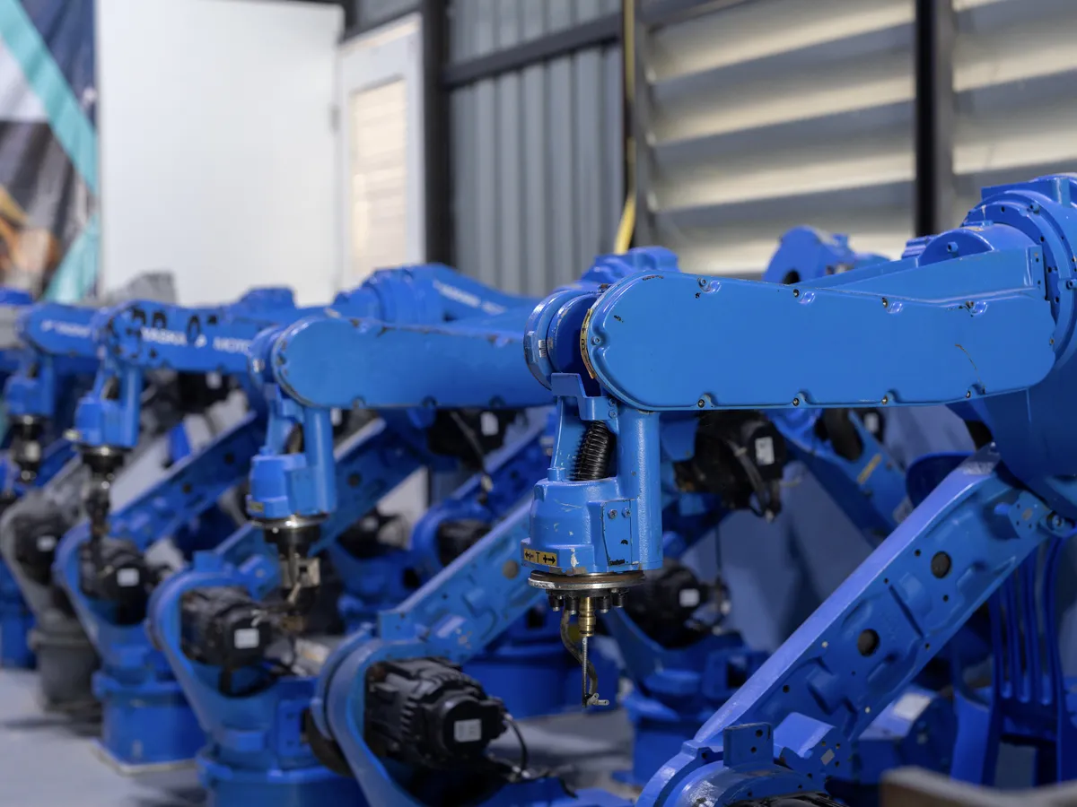 Robotic arms aligned in a row in an industrial factory