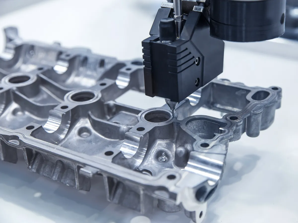 Automated machine arm with a sensor measuring the dimensions of an aluminum die casting part