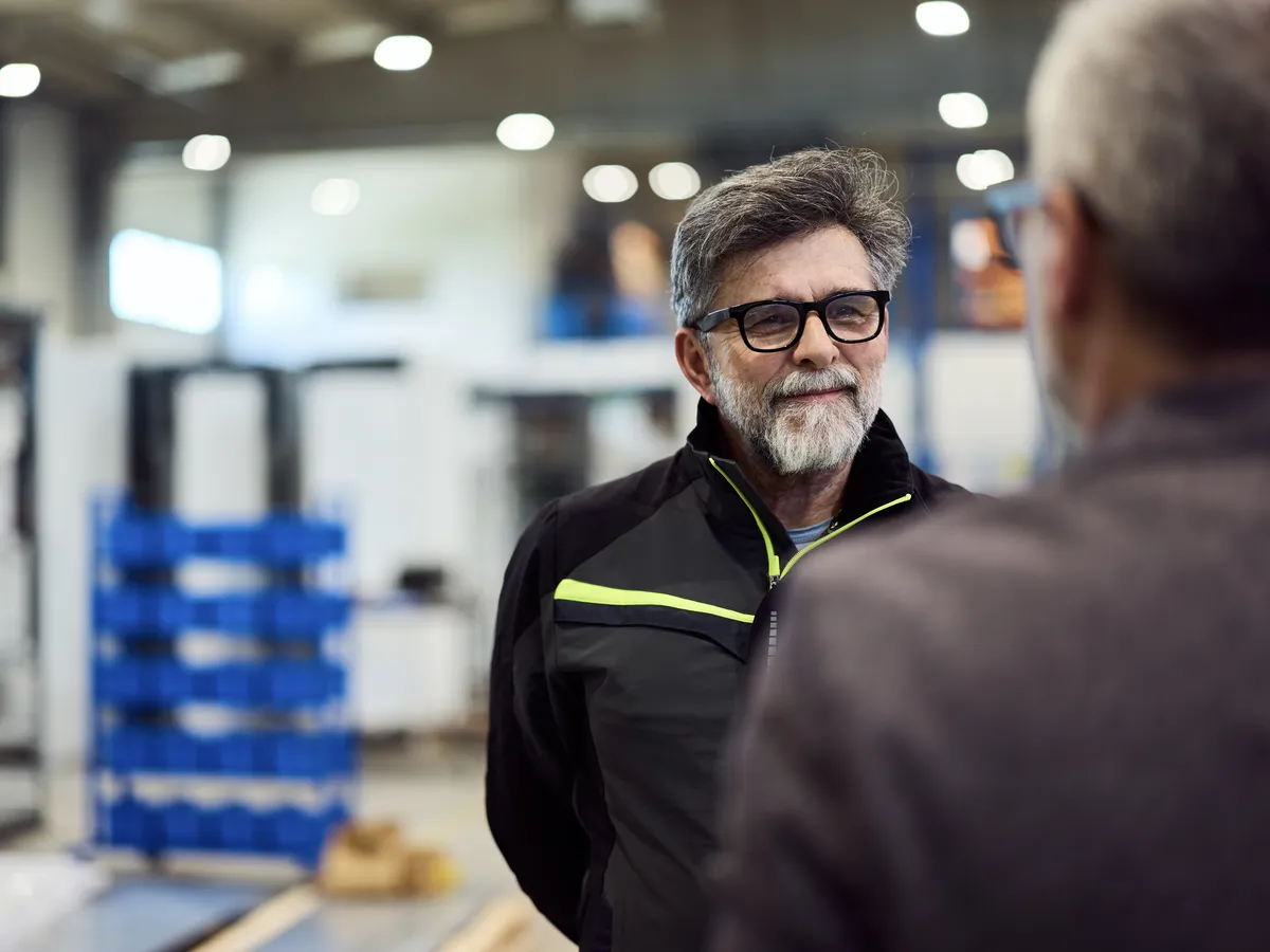 Two men having a discussion in a factory setting