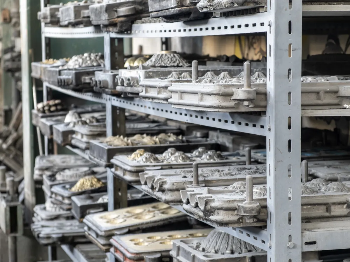 Metal molds on shelves in a manufacturing workshop