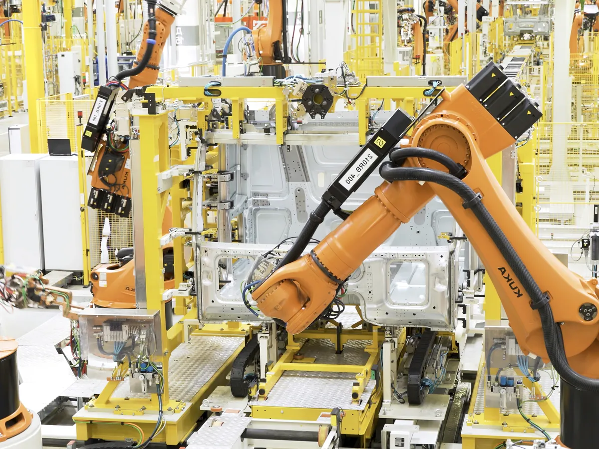Robotic arms welding car parts in a factory