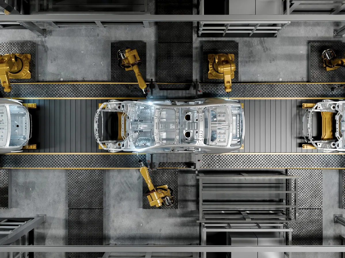 High-angle shot of robotic arms assembling a car chasis on an industrial factory line