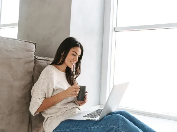 Woman completing a quick online intake form on her laptop for weight loss program.