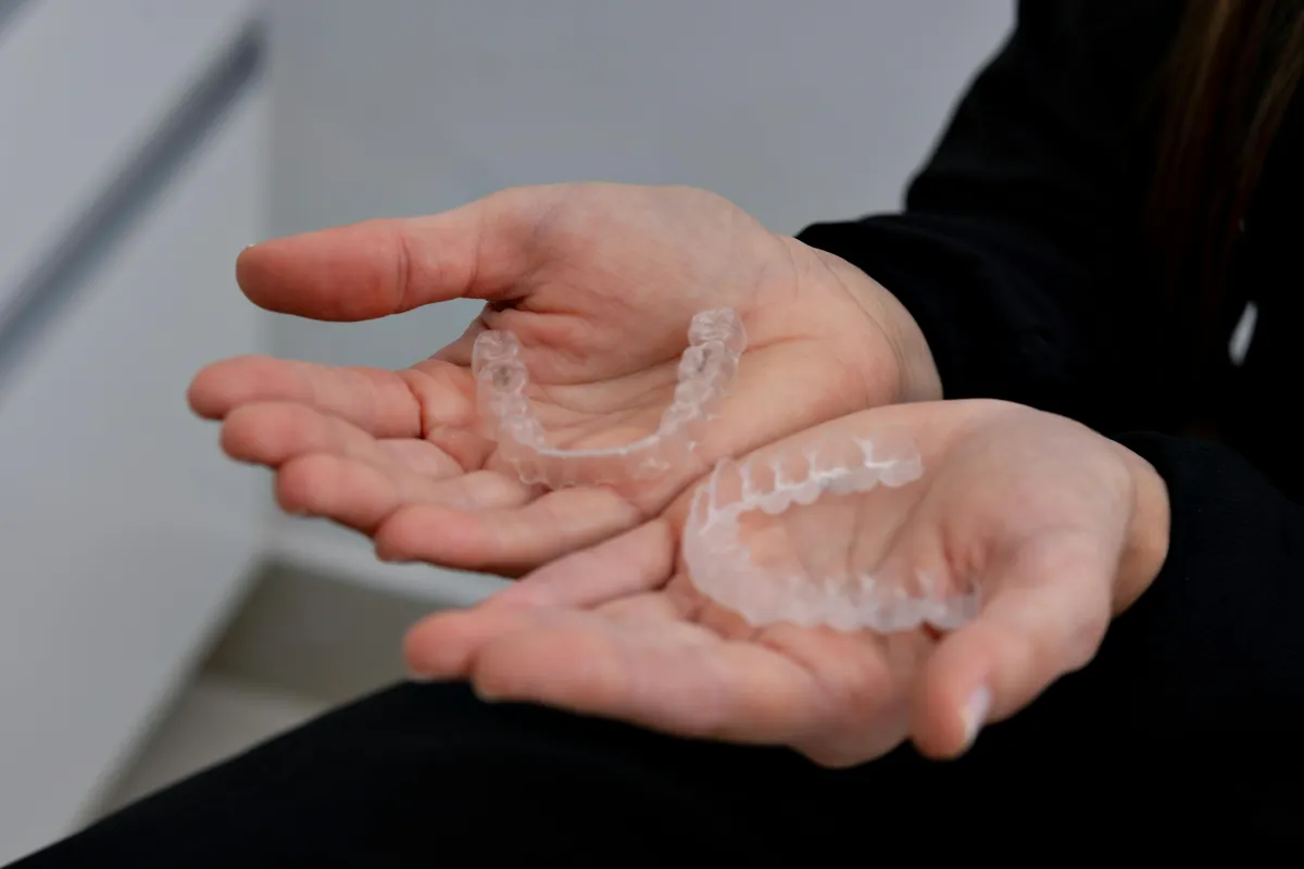 Hands holding Invisalign aligners