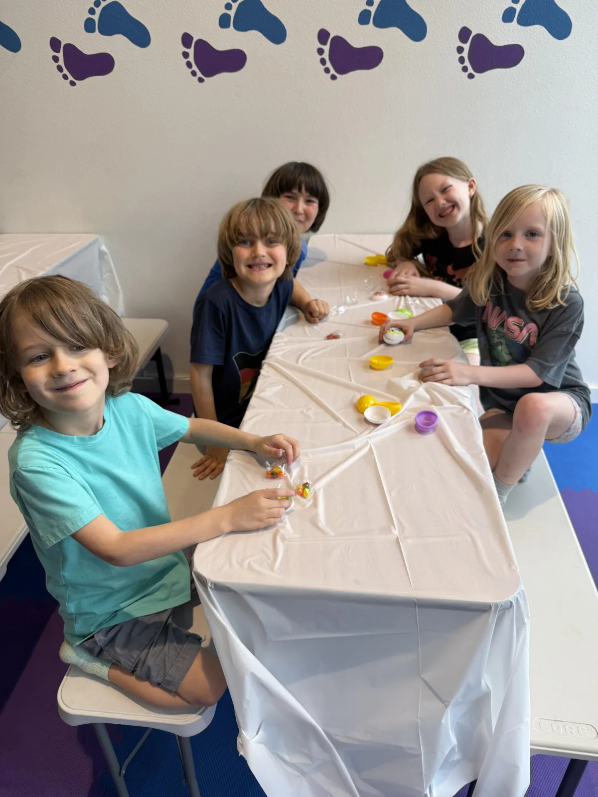 Kids doing crafts at a table inside Wild Child indoor playground in Bastrop, TX