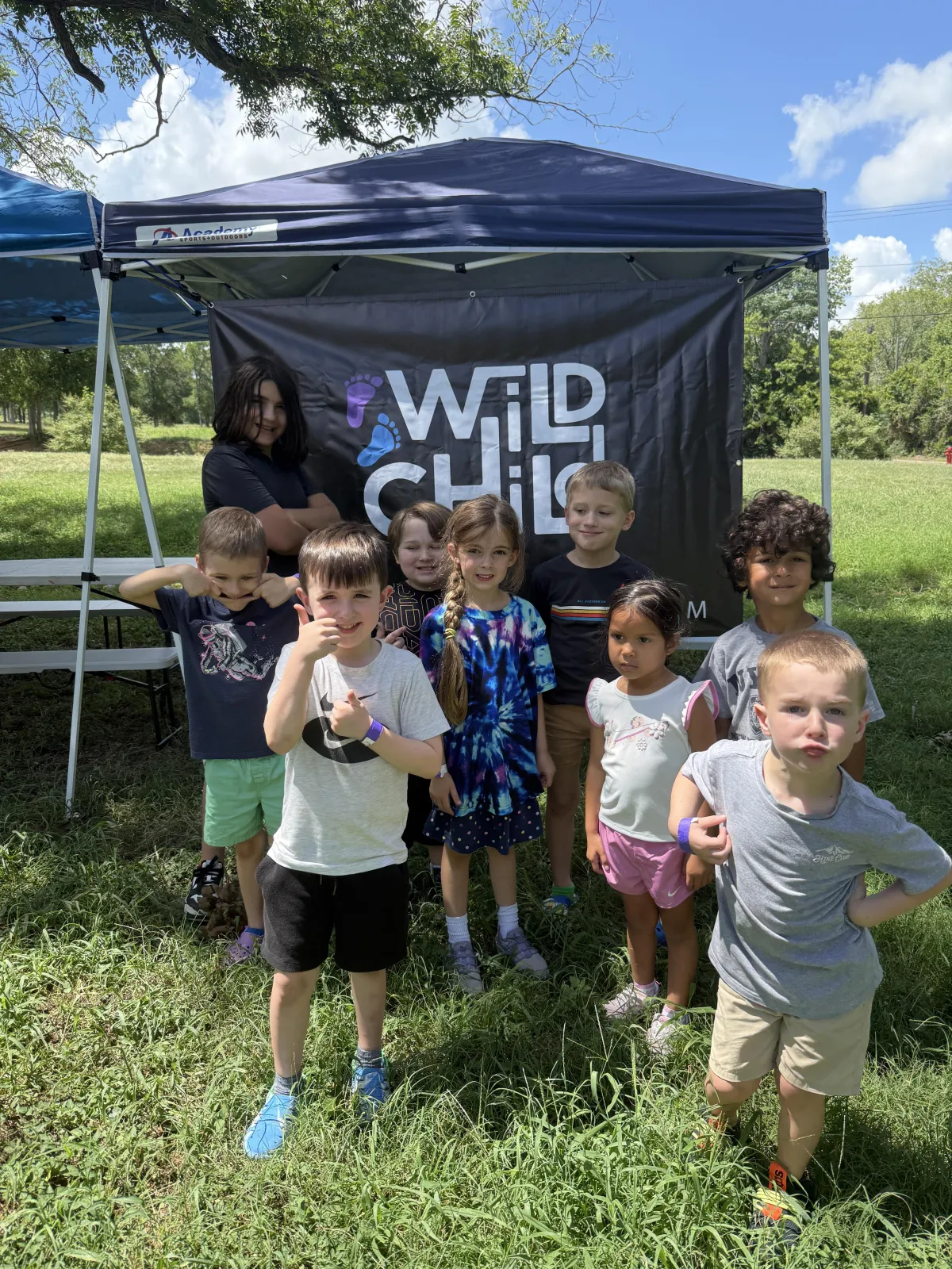 Group of happy children participating in a fitness class at Camp Wild Strive in Bastrop, TX.