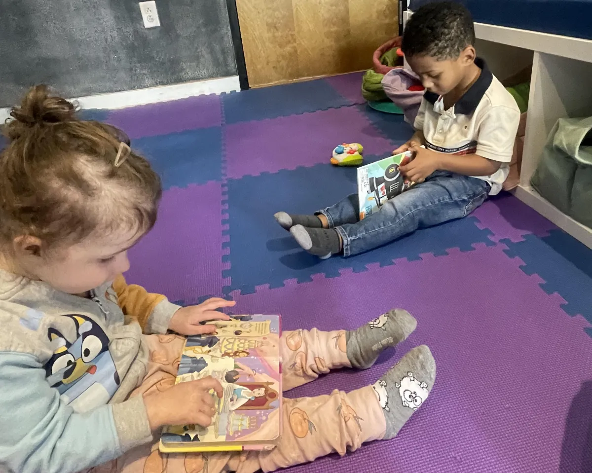 Child listening to a story and looking at picture books during Story Time at Wild Child Bastrop.