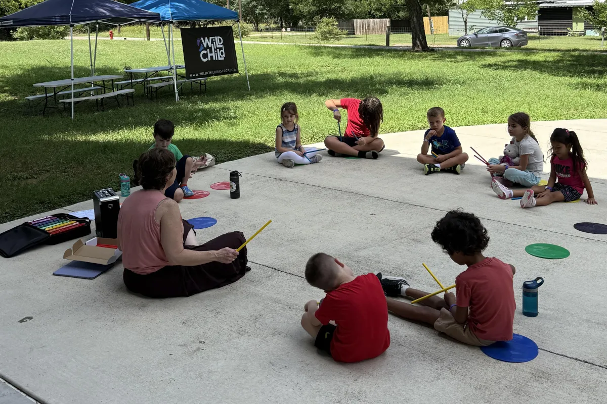 Children singing, dancing, and playing instruments during Music 101 class at Wild Child Bastrop.