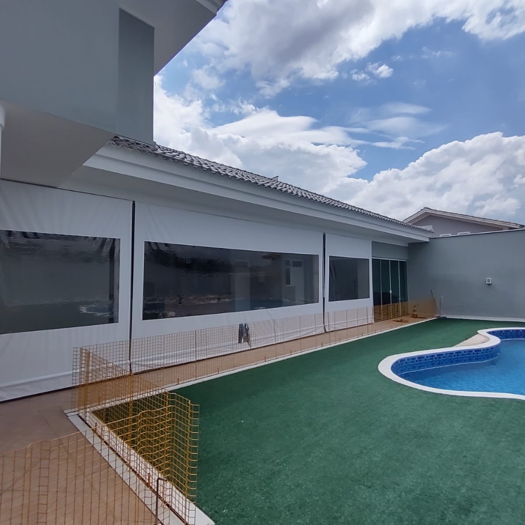 Toldo cortina com visor transparente fechando área de piscina em condomínio de alto padrão