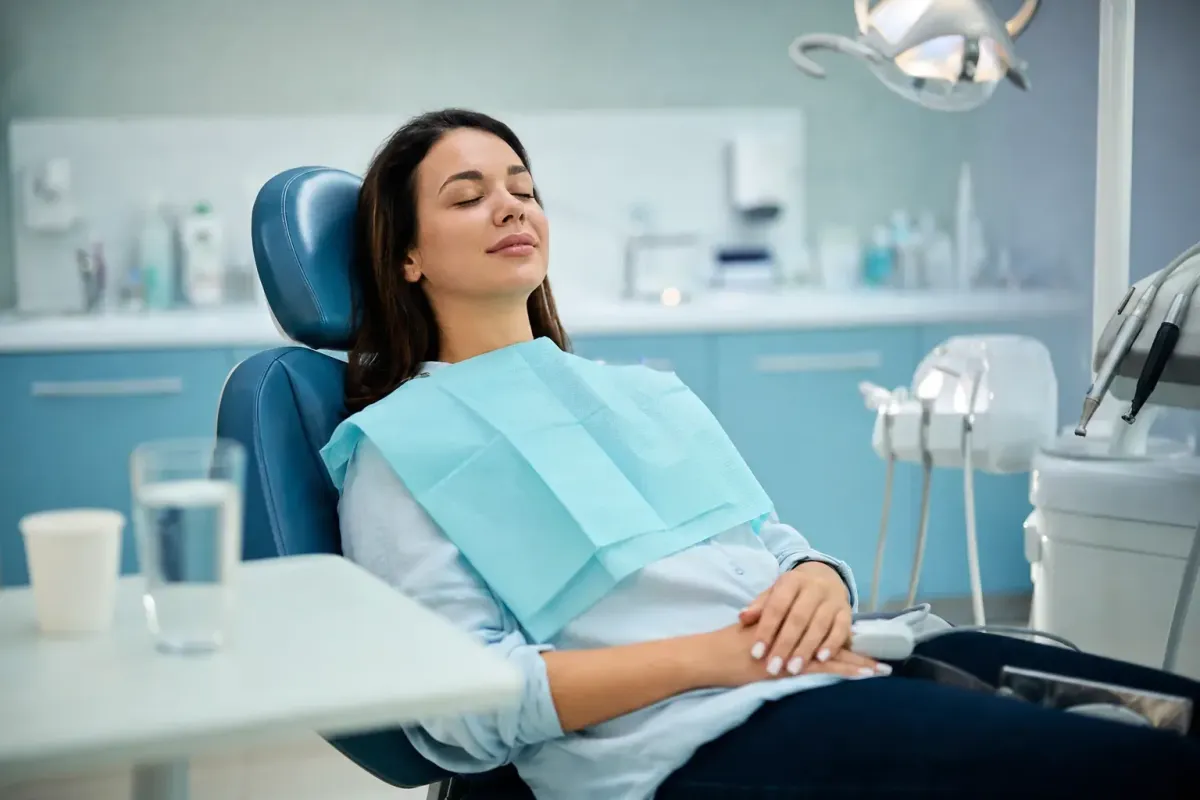 Relaxed dental patient after oral sedation with a pulse oximeter on the finger