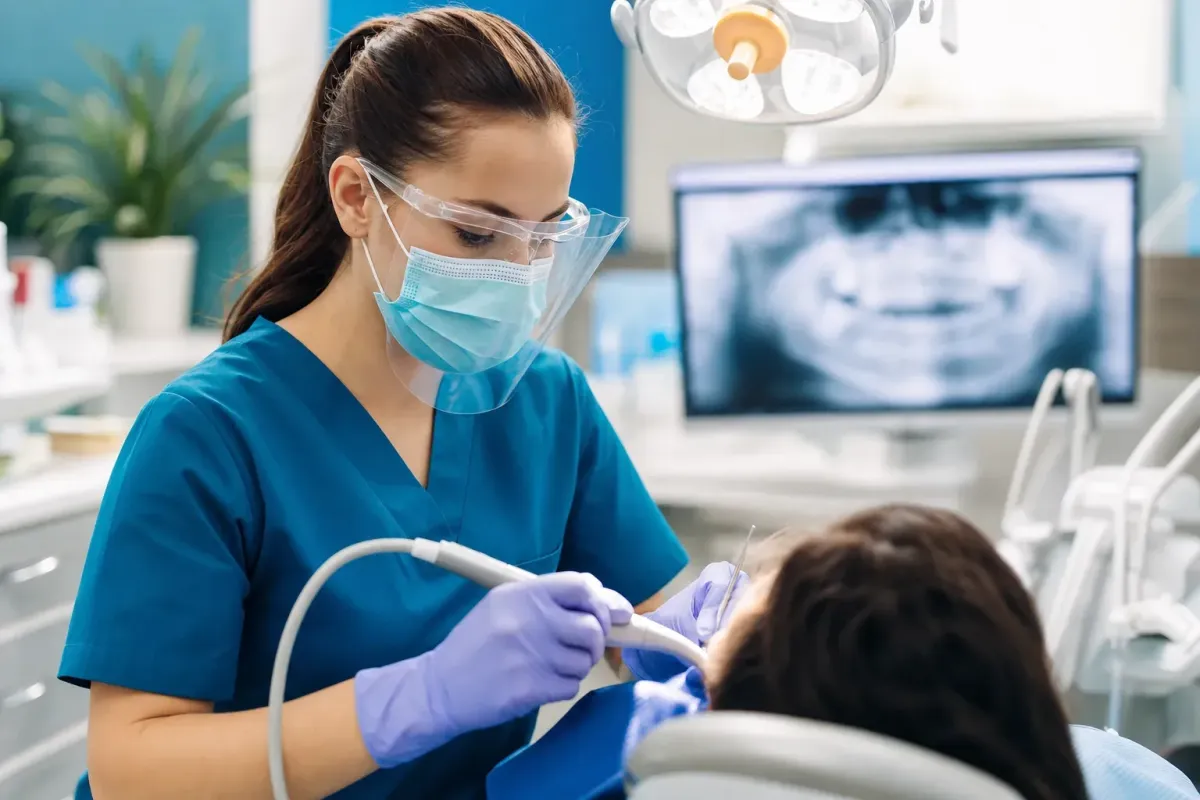 Dental hygienist or assistant working in a modern operatory representing the dental allied workforce