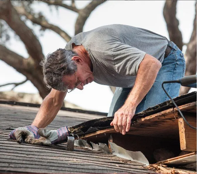 man inspecting a roof for damages