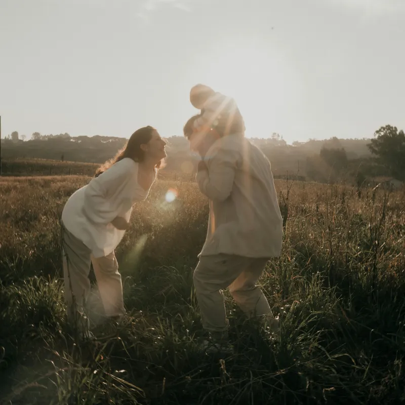 Romantic couple laughing together in a sunlit meadow at golden hour, capturing joy, connection, and healthy relationship growth in a natural outdoor setting.