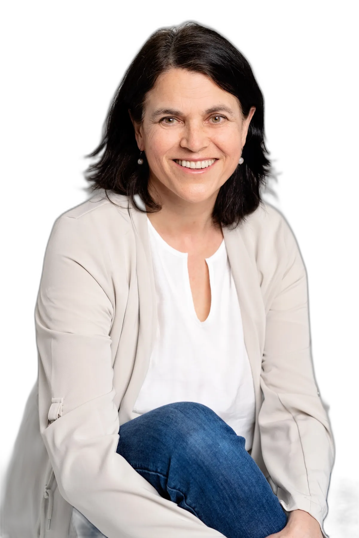 Smiling woman seated comfortably on a chair, exuding warmth and confidence.