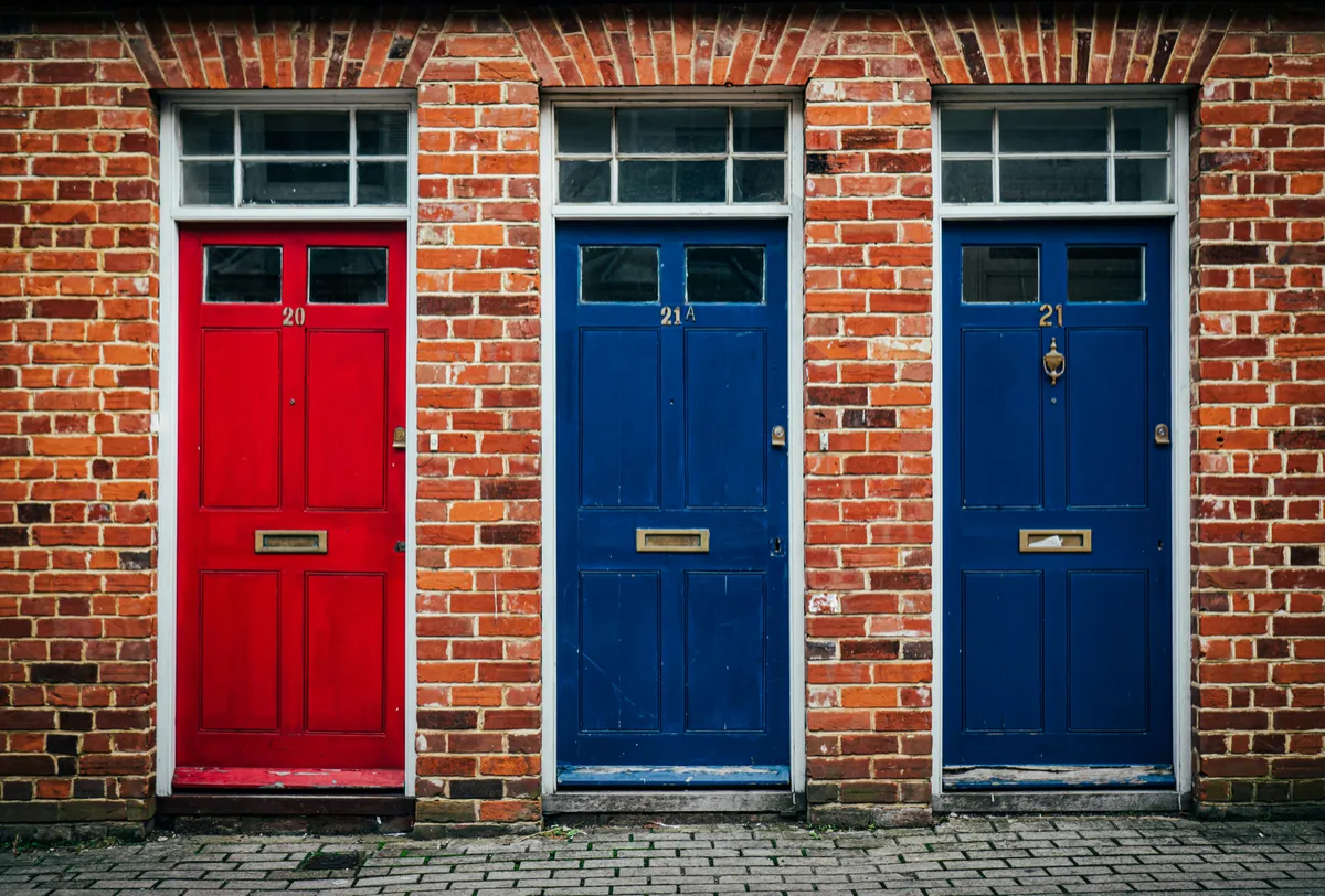 Three separate doors along the exterior of a European style brick building