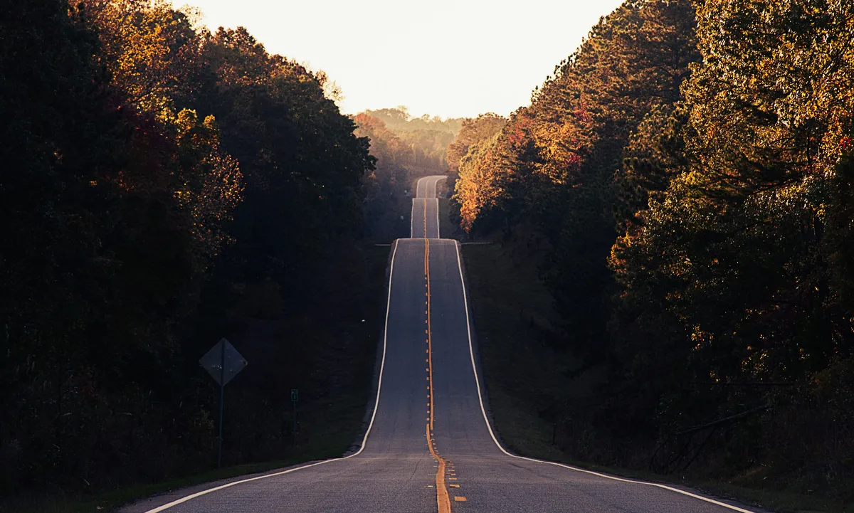An empty road stretching uphill into the distance