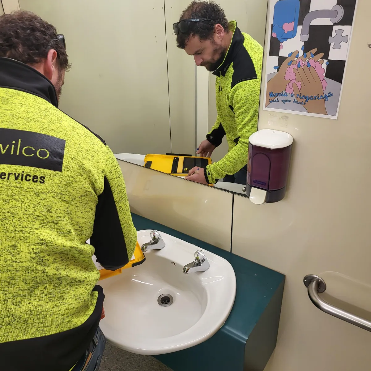 a person working on a sink in a bathroom