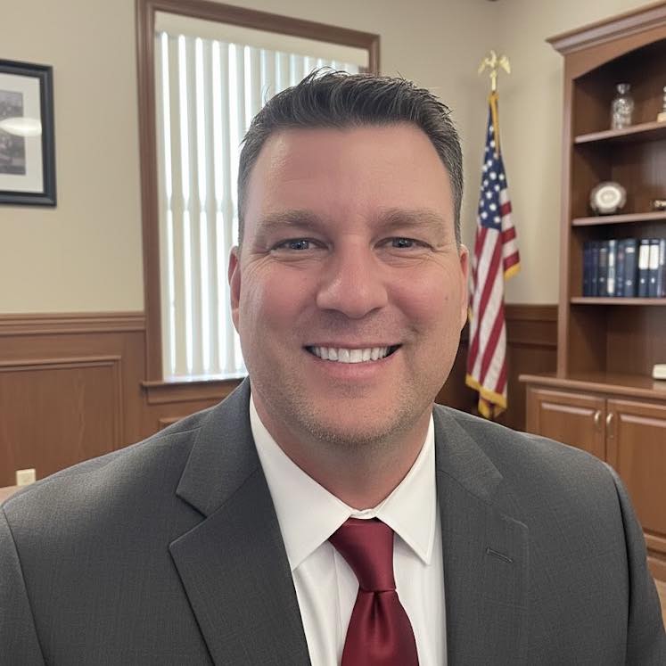 three men sitting while using laptops and watching man beside whiteboard