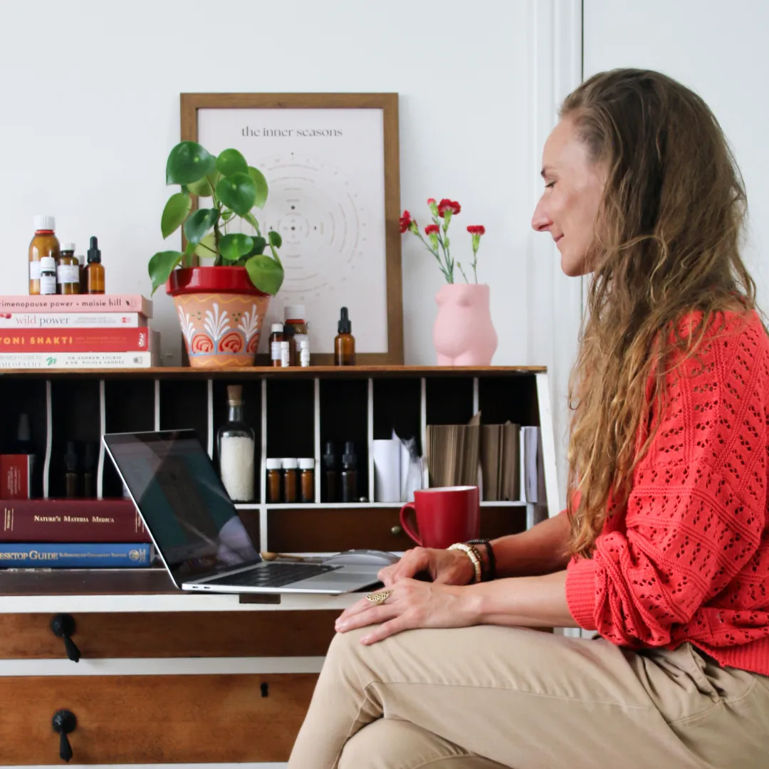 Anna Bihari homeopath sitting in front of her laptop, doing an online homeopathic consultation